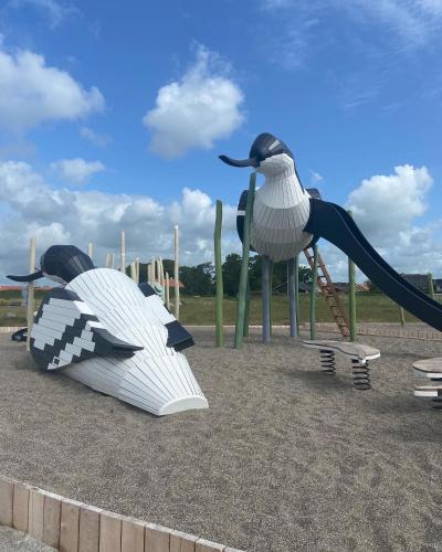 a playground with a slide and a penguin statue at Det blågrønne Hus in Hals
