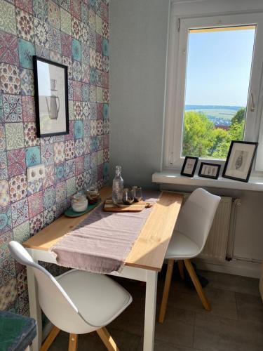 ein Esszimmer mit einem Tisch, Stühlen und einem Fenster in der Unterkunft Appartment Anna-Louise in Sondershausen