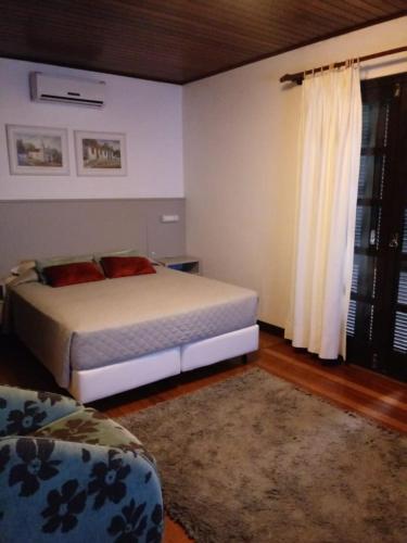 a bedroom with a bed and a window and a rug at Pousada Solar Inn in Torres