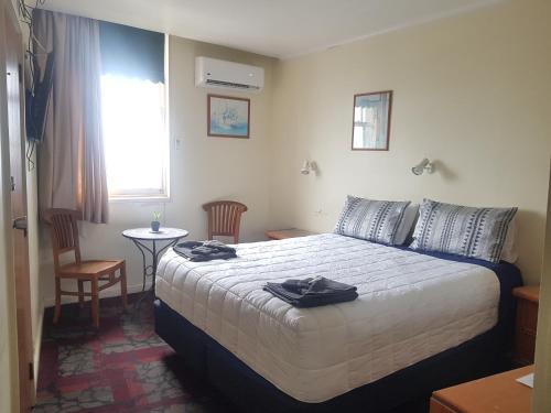 a hotel room with a bed with towels on it at Northern Wairoa Hotel in Dargaville