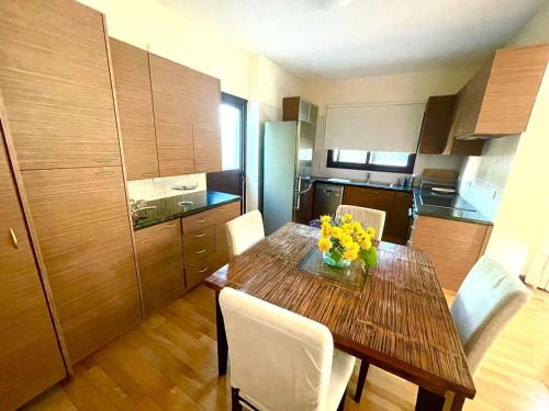 eine Küche mit einem Holztisch mit gelben Blumen darauf in der Unterkunft Irinas country home! in Trimiklini