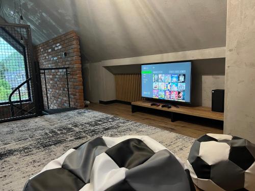 a living room with a large tv and a couch at Dom z basenem Bałtów 22 in Bałtów