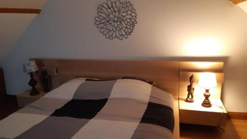 a bedroom with a bed with a black and white comforter at l appart in Dourdan