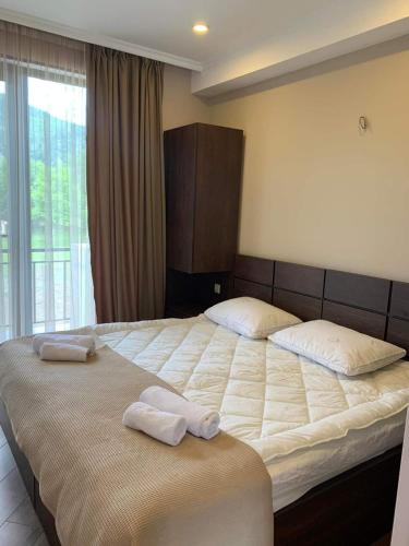 a bedroom with a large bed with towels on it at Green Mountain Borjomi in Borjomi