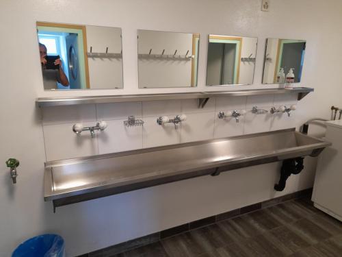 a bathroom with a stainless steel sink and mirrors at Ostello Santa Maria 6541 Santa Maria in Santa Maria