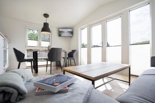 ein Wohnzimmer mit einem Tisch und einem Esszimmer in der Unterkunft Ferienhaus "TO HUUS" mit kostenfreier Saunanutzung in Scharbeutz
