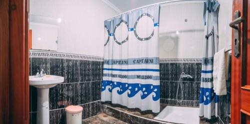 un bagno con tenda da doccia e lavandino di Dar Rita a Rabat