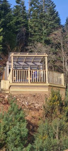 a wooden house on top of a hill with trees at Nadurra But and Ben - Where the Ordinary Becomes Extraordinary in Fort William