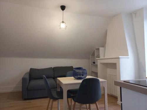 a living room with a couch and a table and chairs at Le Montjoux, appartement calme, toutes commodités in Besançon
