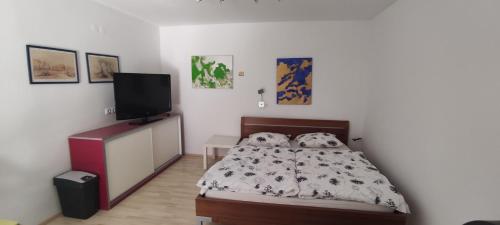 a bedroom with a bed and a flat screen tv at Studio Marjetica in Zgornje Gorje