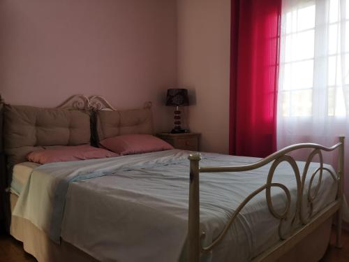 a bedroom with a bed with pink pillows on it at Perithia Cottage in Perítheia