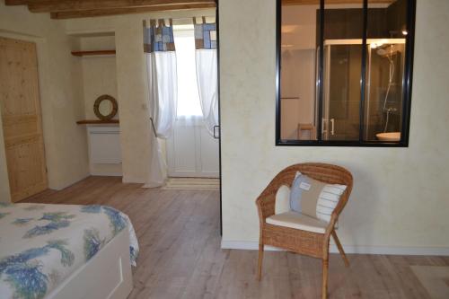 ein Schlafzimmer mit einem Bett, einem Stuhl und einem Spiegel in der Unterkunft Escale à Villeperdue chambre Hellulaug in La Barillonnerie