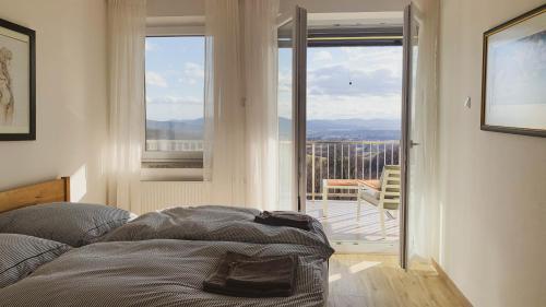 a bedroom with a bed and a view of a balcony at Yellow House Grabrovec in Metlika