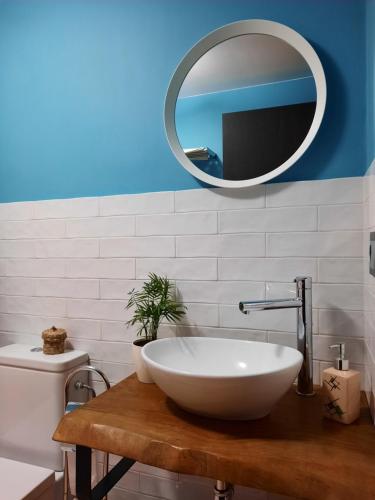 ein Badezimmer mit einem weißen Waschbecken und einem Spiegel in der Unterkunft casa carballal in Lorenzana