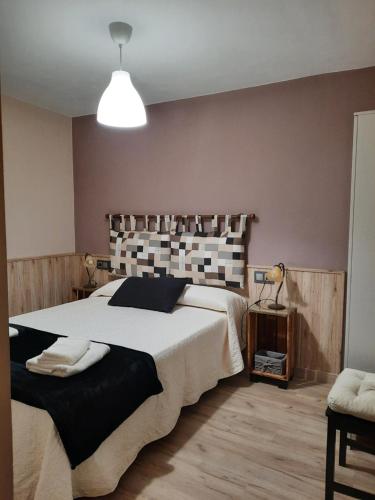 ein Schlafzimmer mit einem großen Bett und einer Lampe in der Unterkunft casa carballal in Lorenzana