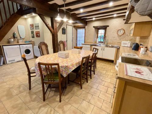 uma cozinha com mesa e cadeiras num quarto em La Foret em La Châtre-Langlin