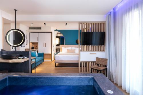 パラリア・カテリニスにあるSKS Luxury Suites & Roomsのバスルーム(青いバスタブ付)が備わるホテルルームです。