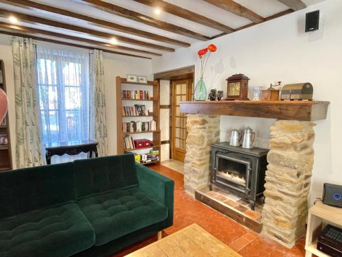 - un salon avec un canapé vert et une cheminée dans l'établissement La Foret, à La Châtre-Langlin