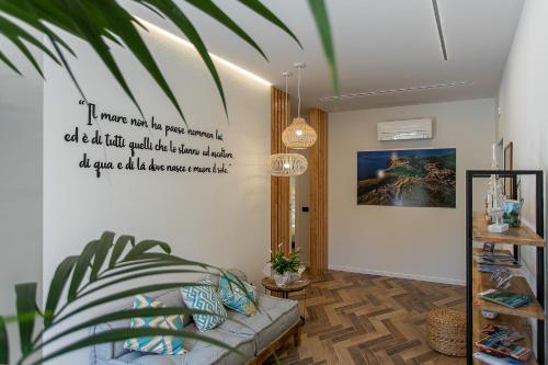 a living room with a couch and a poster on the wall at Brezza Marina Guest House in Porto Ercole