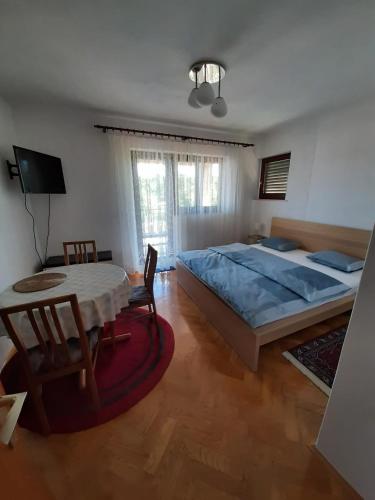 a bedroom with a large bed and a table at Apartment Ivan in Vantačići