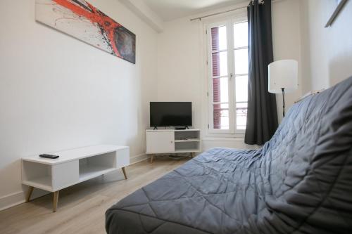 a bedroom with a bed and a desk and a television at Cœur historique classé in Périgueux