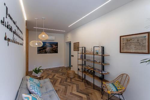 a living room with a couch and a book shelf at Brezza Marina Guest House in Porto Ercole
