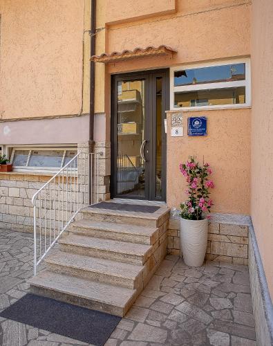 a door of a building with stairs and flowers at Brezza Marina Guest House in Porto Ercole