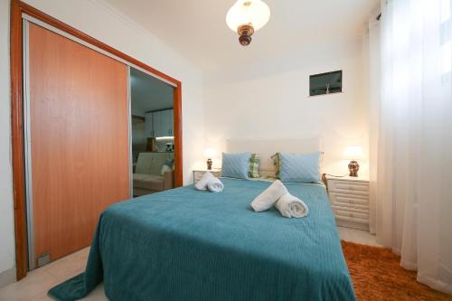 une chambre avec un lit bleu avec deux oreillers dessus dans l'établissement ManelMar O Refúgio, à Nazaré