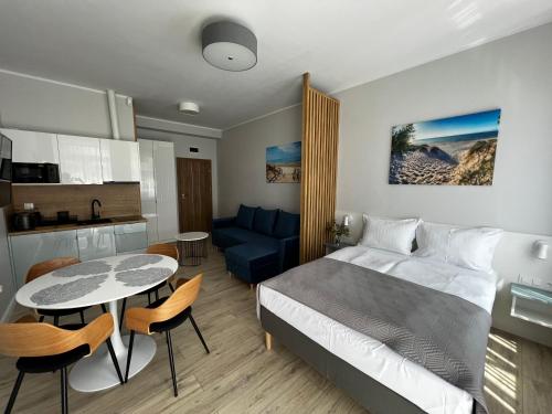 Cet appartement comprend une chambre avec un lit et une table ainsi qu'une cuisine. dans l'établissement WILLA LAZUR, à Łeba