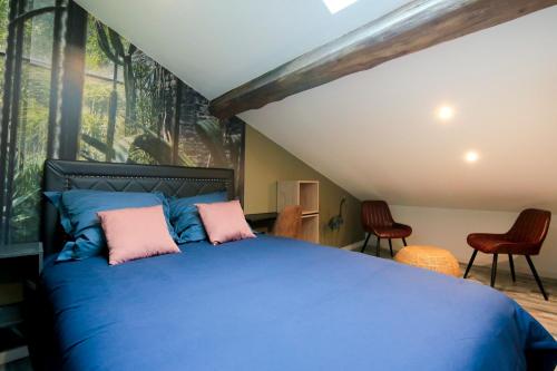 a bedroom with a blue bed with two pink pillows at Le Classy, T3 hypercentre chic et cosy, Wifi par SOVALFI in Saint-Étienne
