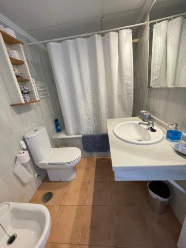 un baño con inodoro y lavabo en Cala Marina, en La Herradura