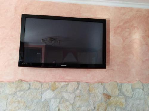 uma televisão de ecrã plano numa parede de pedra em La tavernetta a Trinitapoli em Trinitapoli