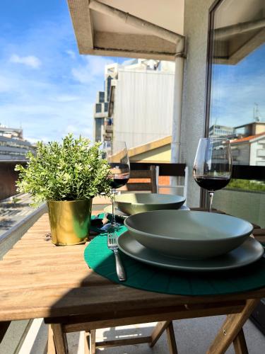 a table with two glasses of wine on a balcony at Boavista YourHome in Porto