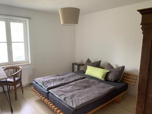 Bett in einem Zimmer mit einem Tisch und einem Fenster in der Unterkunft Apartment Am Jakobsweg in Erfurt