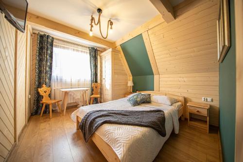 1 dormitorio con 1 cama en una habitación con paredes de madera en Willa Siklawa, en Zakopane