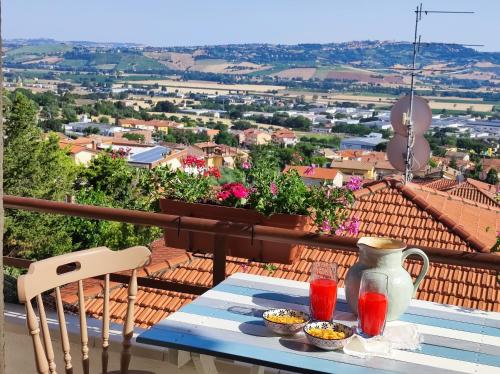 een tafel met een vaas en kommen eten op een balkon bij Camere Infinity Rooms in Castelfidardo