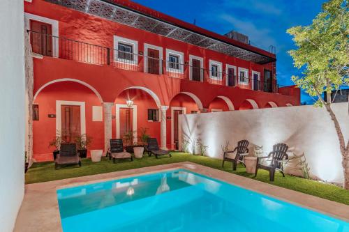 Casa con piscina frente a un edificio en Hotel HO Merida en Mérida