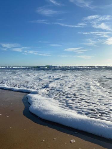 a view of the ocean with foam on the beach at Hostal Los Mellizos in Conil de la Frontera