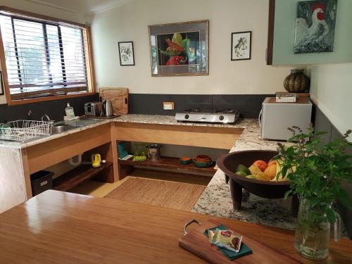 a kitchen with a table and a bowl of fruit at Garden Studio in Jaggan
