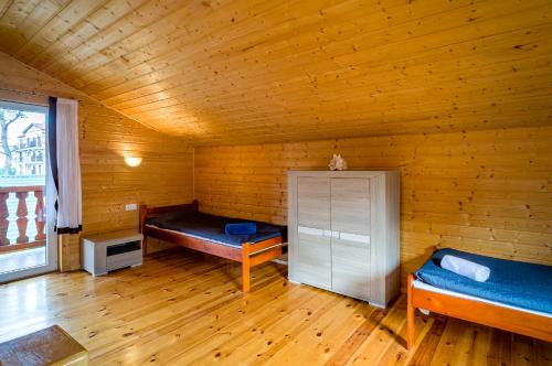 a room with two beds in a wooden room at Morska Osada domki blisko morza in Krynica Morska