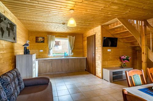 a kitchen and living room in a log cabin at Morska Osada domki blisko morza in Krynica Morska