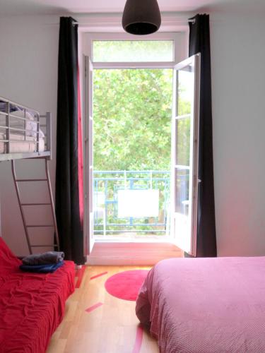 une chambre avec un lit et une grande fenêtre dans l'établissement Appartement vue latérale sur océan, à Saint-Nazaire