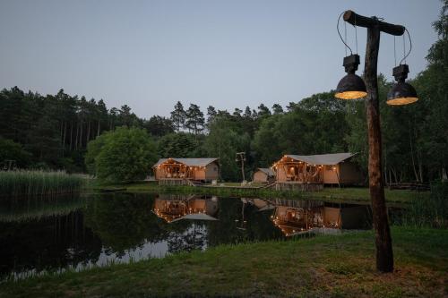 a group of lodges next to a body of water at Urzeka in Drzewce