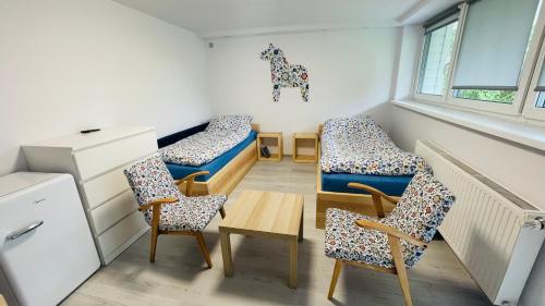 a room with two beds and chairs and a table at Długa 100 in Charzykowy