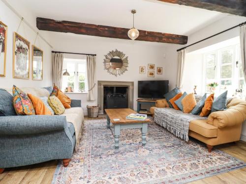 a living room with two couches and a table at Henhouse Farm in Hereford