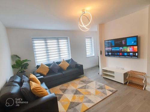 a living room with a couch and a flat screen tv at Lovely home close to City Center & Rail Station in Chesterfield