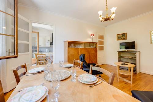une salle à manger avec une grande table et des chaises en bois dans l'établissement T2 de 55m pouvant accueillir 3 personnes, à Annecy