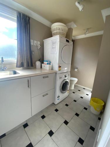 a kitchen with a washer and dryer in it at Twin Totara Cottage in Upper Hutt