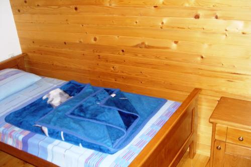 a room with a bed with a wooden wall at Apartmani panorama in Žabljak