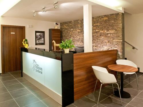 a lobby with a counter with a table and chairs at Penzion v jízdárně in Olomouc